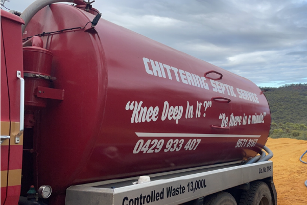 Side of a Chittering Septic Service tanker painted with the motto “Knee deep in it? Be there in a minute!” and the phone number